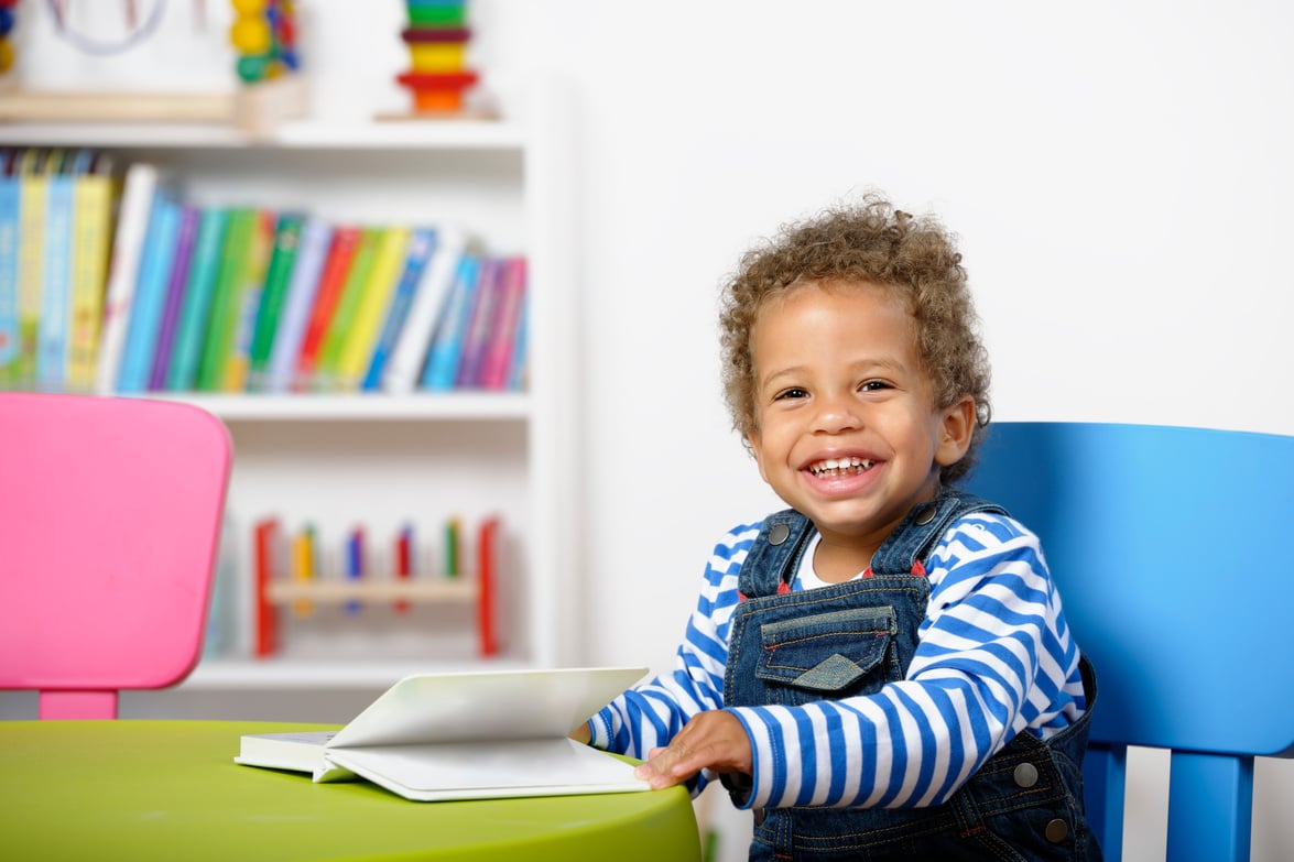 Happy Biracial Toddler Enjoying Storytime In A Nursery Setting