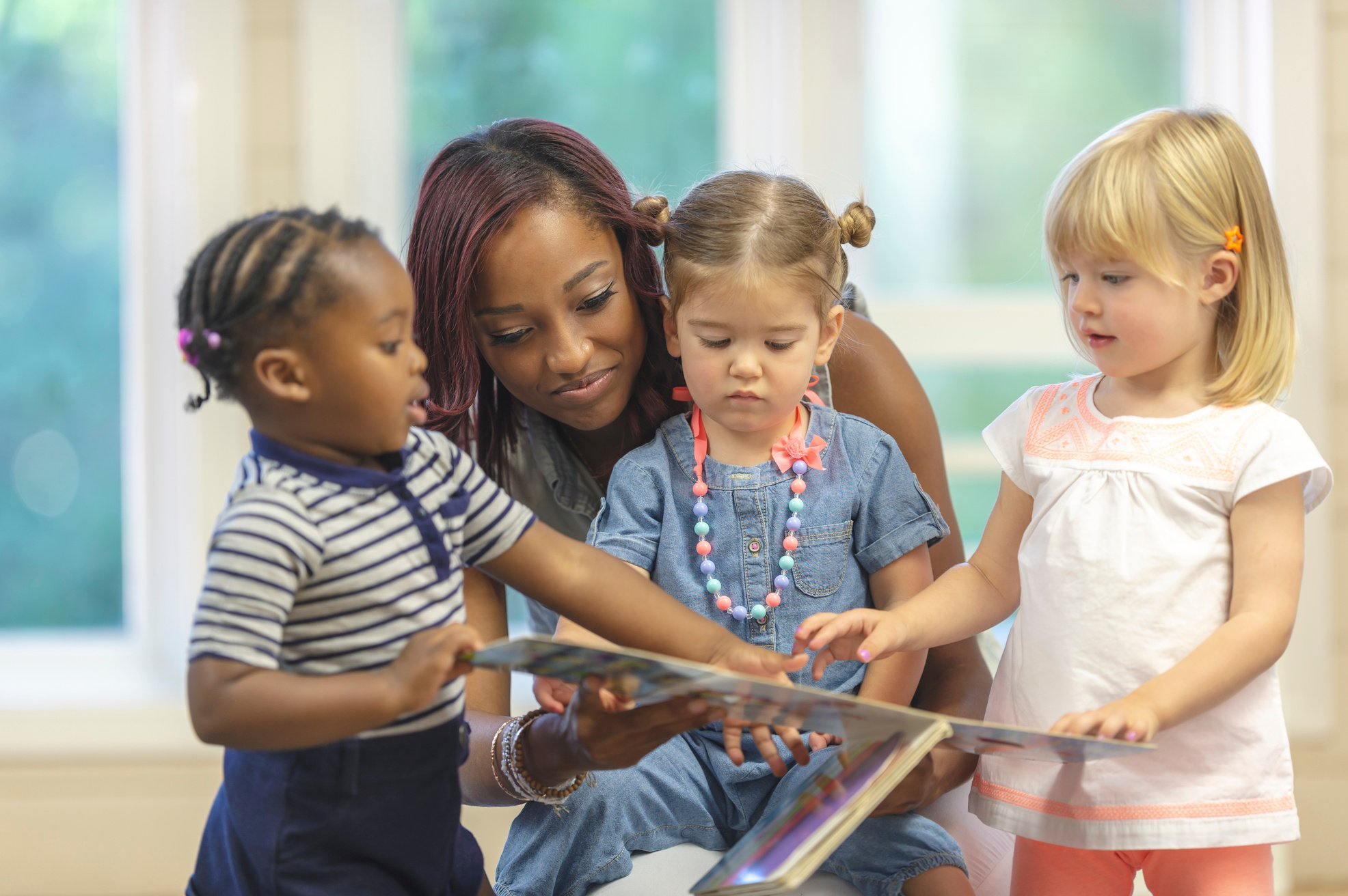 Preschool children reading with teacher