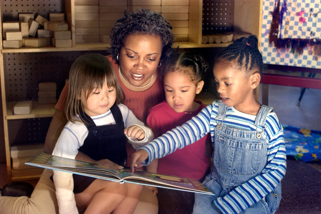 Children and teacher reading in preschool classroom